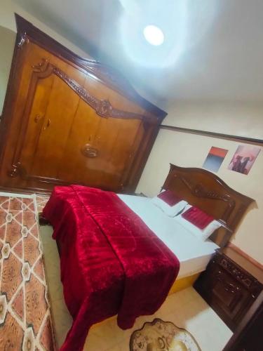 una camera da letto con un letto grande con una coperta rossa di كورنيش النيل البحر الاعظم a Il Cairo