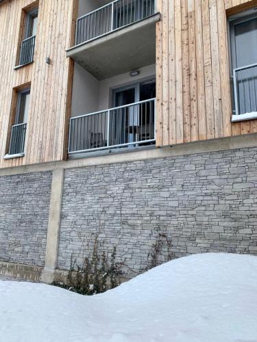 a brick building with windows and snow in front of it at Apartmán Jestřáb Janské Lázně in Janske Lazne