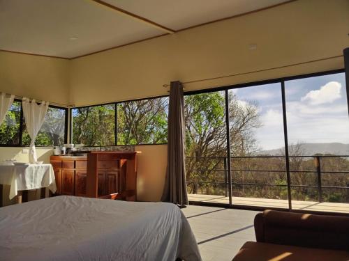 a bedroom with a bed and a large window at Cielo Azul in Monteverde Costa Rica