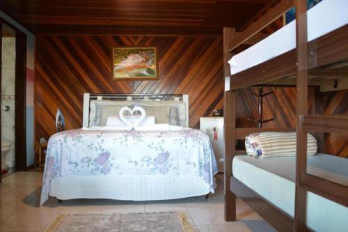 un dormitorio con una cama y una litera en Pousada Coração da Ilha, en Ilha do Mel