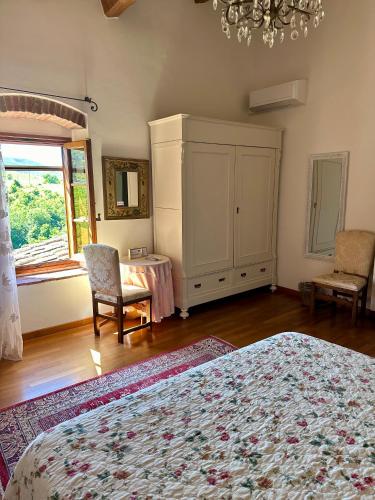 a bedroom with a bed and a cabinet and a window at Casale Le Masse in Greve in Chianti