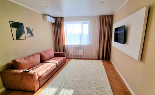 sala de estar con sofá marrón y ventana en Arman, en Kokshetau