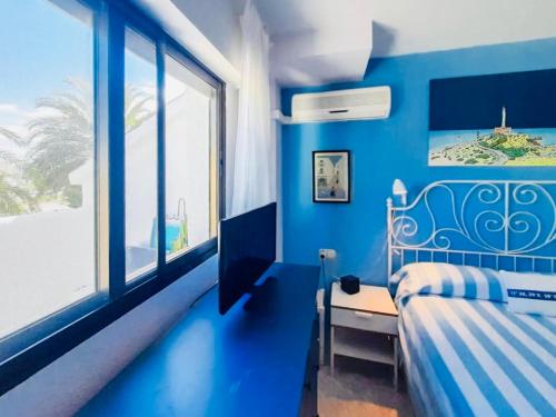 a blue bedroom with a bed and a window at LMHA25, Puerto Latino 11, Tomas Maestre Marina, La Manga in La Manga del Mar Menor