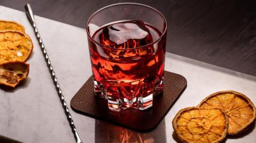 a drink in a glass on a coaster with a slice of orange at Holiday Inn Singapore Atrium by IHG in Singapore