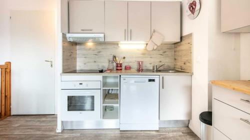 La cuisine est équipée de placards blancs et d'un lave-vaisselle blanc. dans l'établissement Chalets De La Vanoise - Les Chalets de la Vanoise CV1305 MAE-9964, à Villarodin-Bourget