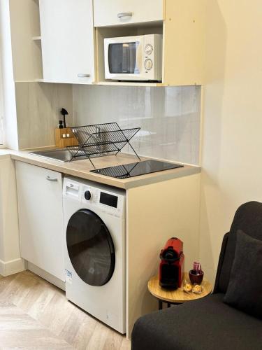 une cuisine avec un micro-ondes et un lave-linge dans l'établissement Studio Champs Elysées Tour Eiffel, à Paris