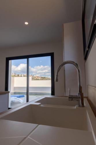 une cuisine avec un évier et une grande fenêtre dans l'établissement Villa Évasion - pour 8 personnes avec vue, à Narbonne