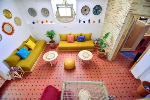 ein Wohnzimmer mit einem Sofa, Tischen und Uhren in der Unterkunft Dar Sekka in Tangier