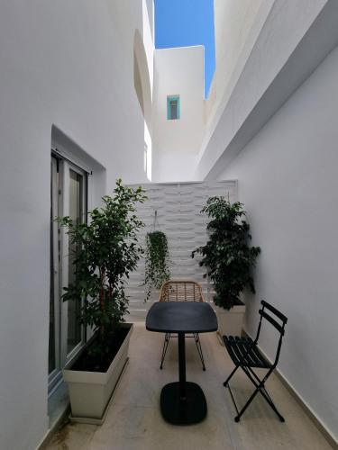 a table and two chairs in a room with plants at Majo Suites Hotel in Agia Anna Naxos