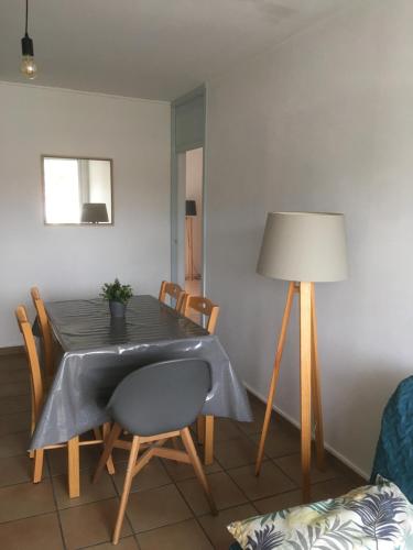 une salle à manger avec une table, des chaises et une lampe dans l'établissement Appartement spacieux Arcachon, à Arcachon