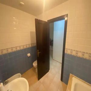a bathroom with a toilet and a black door at Seulement aux familles Luxe appartement en Rdc saidia marina AP2 in Saidia 
