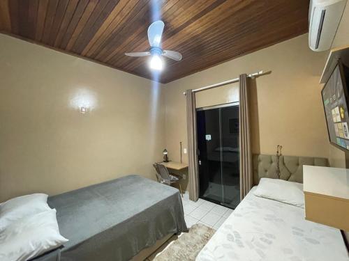Un dormitorio con dos camas y un ventilador de techo. en Smart Suíte, en Boa Vista