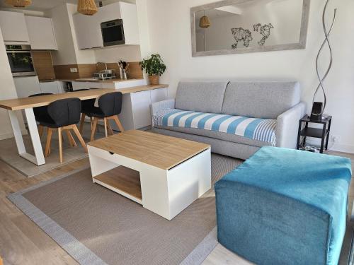 un salon avec un canapé et une table dans l'établissement Le Capitole - Studio Plage Benoit dans résidence face mer, à La Baule