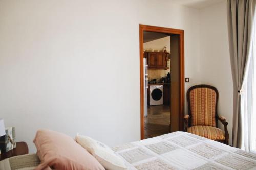 une chambre avec un lit, une chaise et un miroir dans l'établissement Sentier du Clos, à Nemours