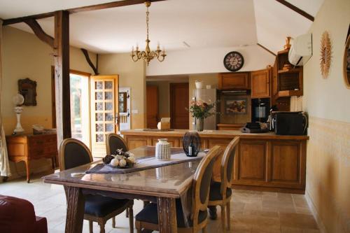une cuisine avec une table et des chaises dans une pièce dans l'établissement Sentier du Clos, à Nemours
