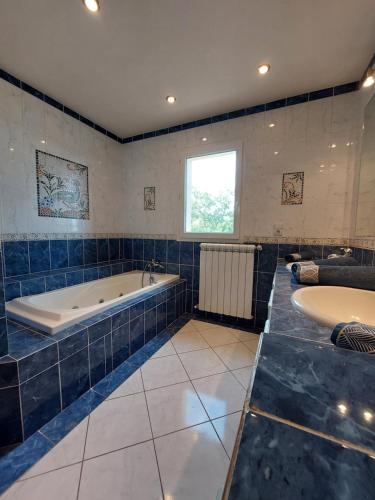 La grande salle de bains est pourvue d'une baignoire et de deux lavabos. dans l'établissement Quiétude Provençale, à Mons