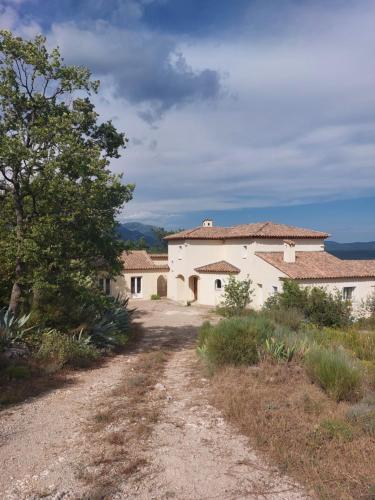 une route vide devant un bâtiment blanc dans l'établissement Quiétude Provençale, à Mons