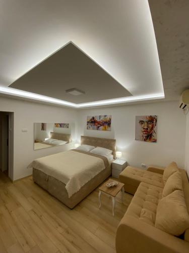 a bedroom with a large bed and a couch at Comfort studio Lepa Kata in Podgorica