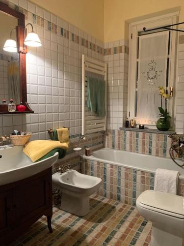 a bathroom with a tub and a toilet and a sink at Locanda del Glis glis in Castelletto d'Orba