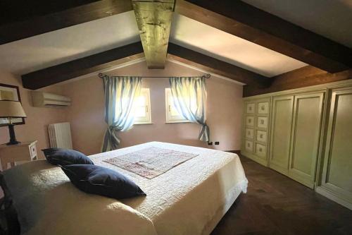 a bedroom with a bed with pillows and a window at Locanda del Glis glis in Castelletto d'Orba