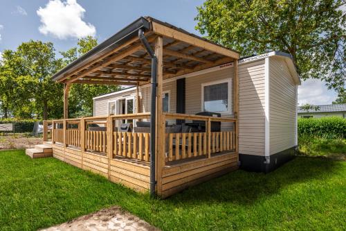 a cabin with a deck with a pergola at Bondi Beach in Renesse