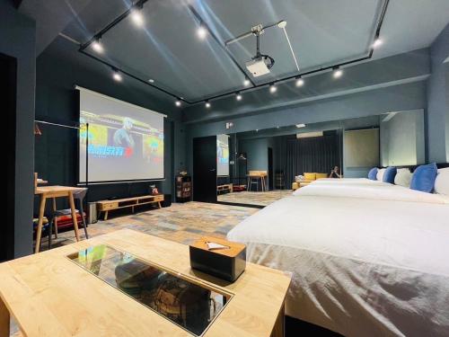 a bedroom with a large bed and a projection screen at 萊恩晴旅包棟民宿 in Magong