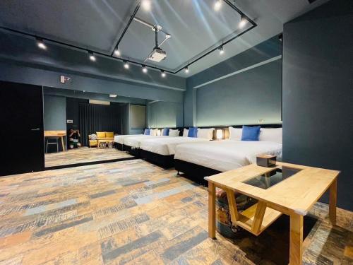 a room with four beds and a table in it at 萊恩晴旅包棟民宿 in Magong