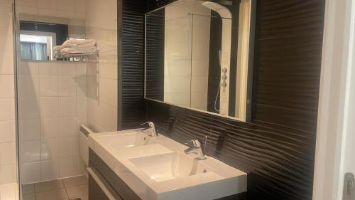 a bathroom with two sinks and a mirror at Boutique Diamond Apartments in Antwerp