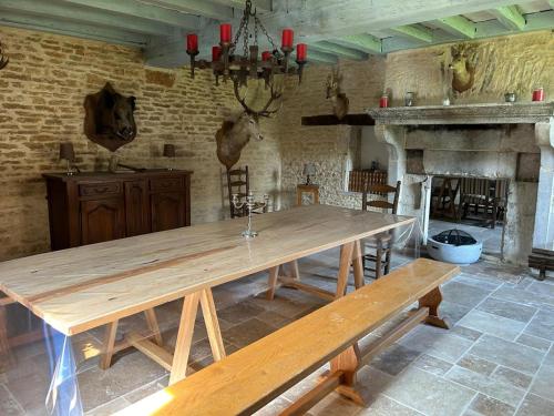 a large wooden table in a room with a fireplace at la bastille de Forfot in Ampilly-le-Sec