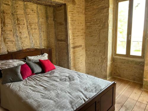 a bedroom with a bed with four pillows at la bastille de Forfot in Ampilly-le-Sec