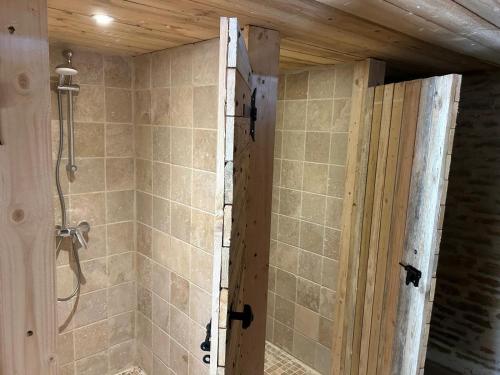 a bathroom with a shower with a door in it at la bastille de Forfot in Ampilly-le-Sec