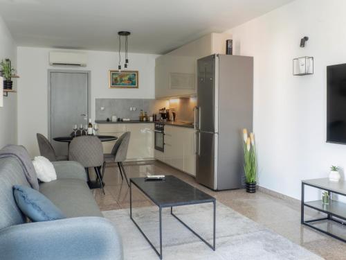 a living room with a couch and a table and a refrigerator at Vertigo 2 Modern 2-Bedroom Apartment with Parking & Vitosha View in Sofia