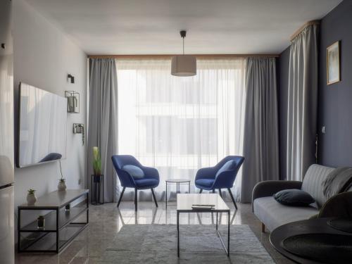 a living room with blue chairs and a couch at Vertigo 2 Modern 2-Bedroom Apartment with Parking & Vitosha View in Sofia