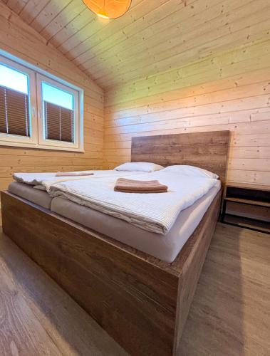 a bedroom with a large bed in a wooden room at Rezort Zvernica Vlachy - Family & Fun in Vlachy