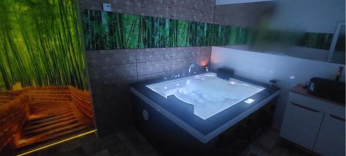 a bathroom with a large tub with a green painting at WILLA NA WYŁĄCZNOŚĆ 12 os BIESZCZADY z Salą Imprezową, Jacuzzi, Sauną, Balią Zewnętrzną oraz 2 baseny z podgrzewaną wodą - Rezydencja Matiaszówka in Polańczyk