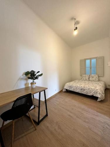 une chambre avec un lit et un bureau avec une chaise dans l'établissement Magnifique Appartement 2 chambres 60m2 Centre Ville Nîmes, à Nîmes