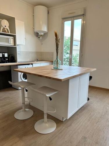 - une cuisine avec un îlot et un vase dans l'établissement Magnifique Appartement 2 chambres 60m2 Centre Ville Nîmes, à Nîmes