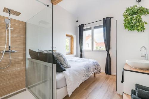 une chambre avec un lit, un lavabo et un miroir dans l'établissement Aux Pierres Dorées 10 min centre de Lyon, à Pierre-Bénite
