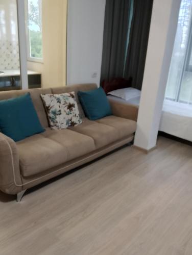 a brown couch with blue pillows in a living room at New Wave1 in Grigoleti
