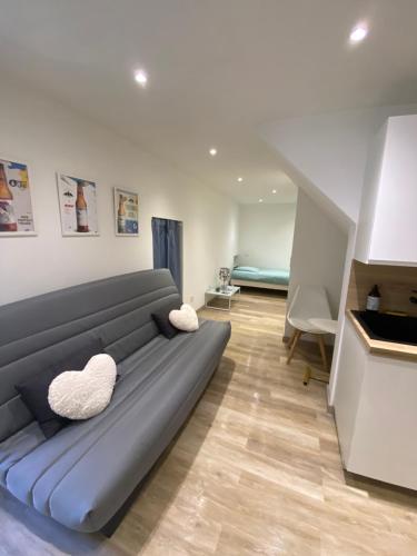 un salon avec un canapé bleu avec deux coussins blancs dans l'établissement Agréable Studio au cœur du village, à Saint-Martin-Vésubie