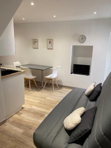 - un salon avec un lit et une table avec des chaises dans l'établissement Agréable Studio au cœur du village, à Saint-Martin-Vésubie