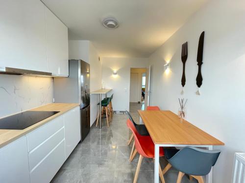 une cuisine avec une table en bois et une salle à manger dans l'établissement PARIS PANTIN Magnifique Appartement 4 pièces de 108m2 avec 2 PARKING intérieur - très cosy pour 1 à 12 personnes - Entièrement refait à neuf ENTIRE APARTMENT LUXURIOUS AND WARM - PANTIN PARIS 19 ème FREE WIFI GRATUIT, à Pantin