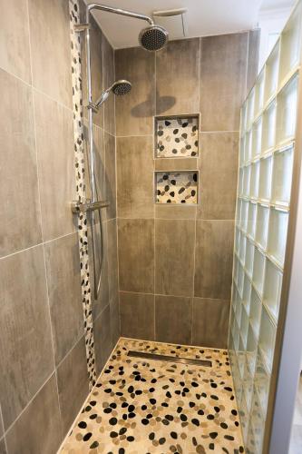 une salle de bain avec une douche avec une porte vitrée dans l'établissement 50 Nuances Rémoises, à Reims