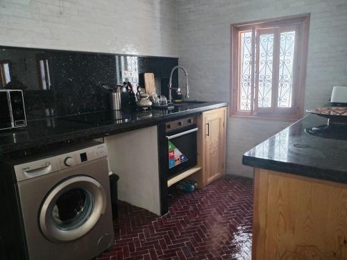 a kitchen with a washing machine and a counter top at El Sama' family house Rooftop 80m2 in Chefchaouene