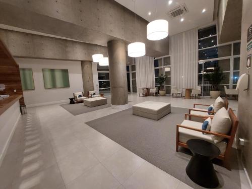 a lobby with two people sitting in chairs in a building at Book Santos - Unlimited 2111 Vista Mar in Santos