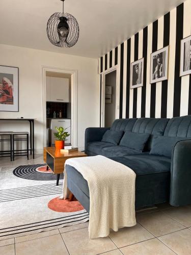 un salon avec un canapé bleu et une cheminée dans l'établissement COSY Apartment near the Center of Paris, Porte de Clichy, à Clichy