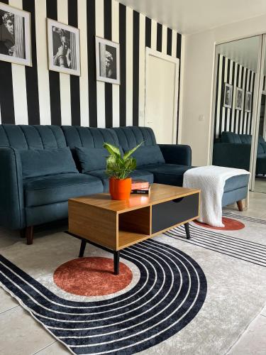 un salon avec un canapé bleu et une table basse dans l'établissement COSY Apartment near the Center of Paris, Porte de Clichy, à Clichy