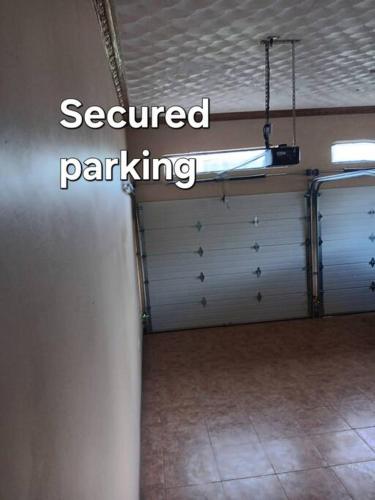 a garage with two garage doors and a sign that says secured parking at B&B Hideaway in Santa Cruz