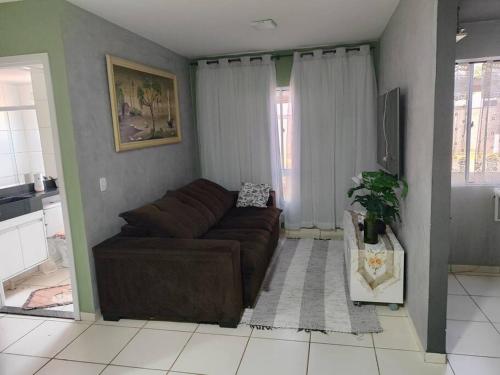 a living room with a brown couch in a room at Apartamento confortável in Campo Grande