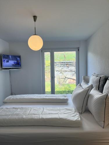 a white room with two beds and a window at Ferienhaus Cris und Alex in Stühlingen